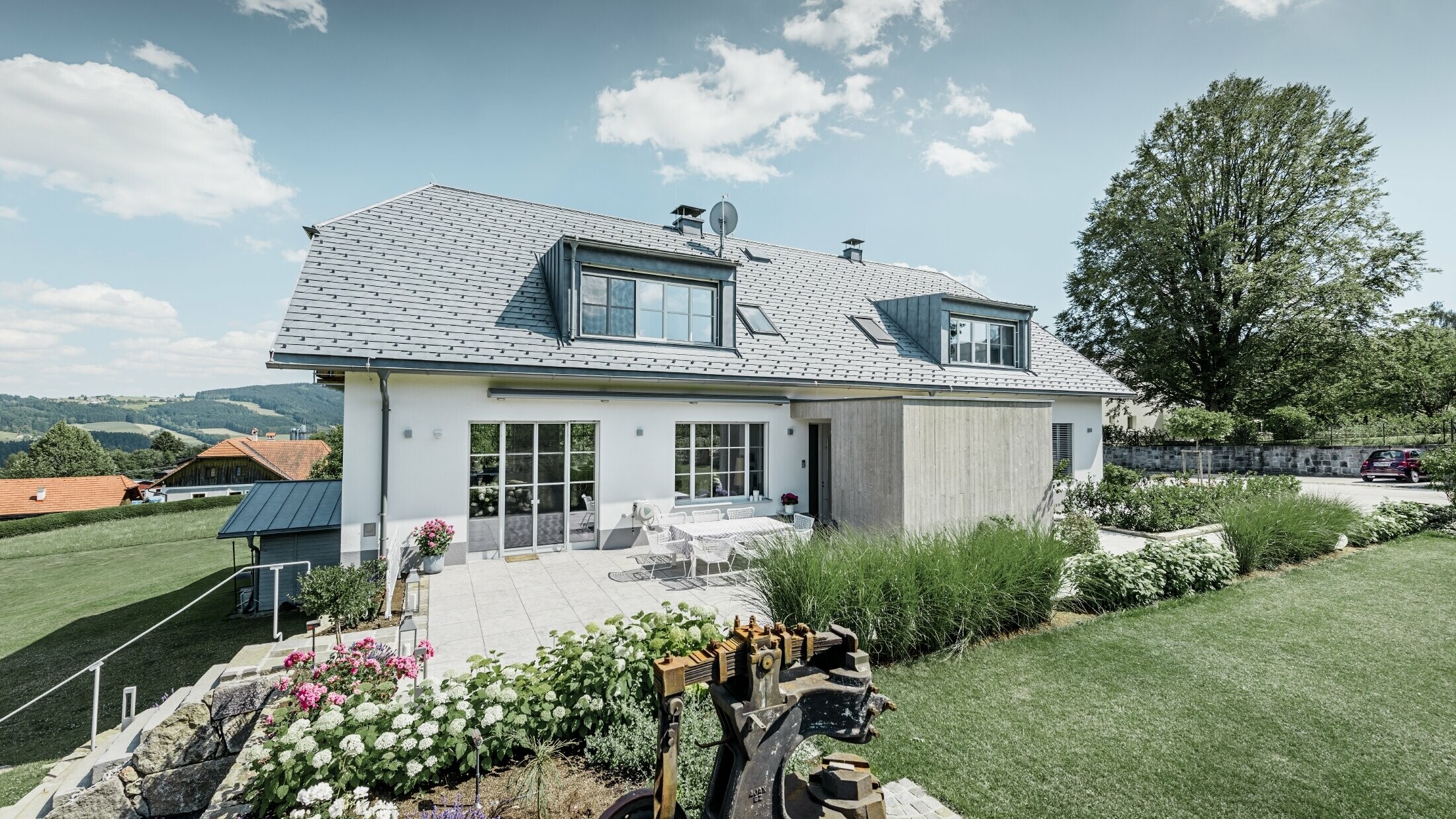 Klassieke eengezinswoning met schilddak met wolfseinden, dakrenovatie met PREFA dakschindels in steengrijs met mooi aangelegde tuin en ruim terras.