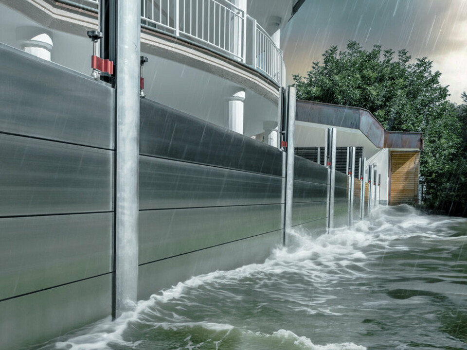 Close-up van de PREFA-hoogwaterbescherming van aluminium, die altijd bestand is tegen overstromingsrampen en het vrijstaande huis op de achtergrond beschermt.