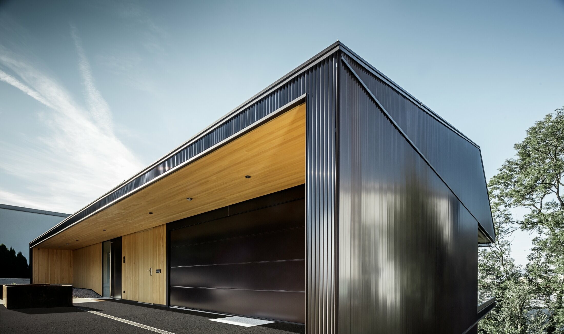 Garage-ingang van een eengezinswoning, de gevel is bekleed met het PREFA kartelprofiel in donkerbruin. 