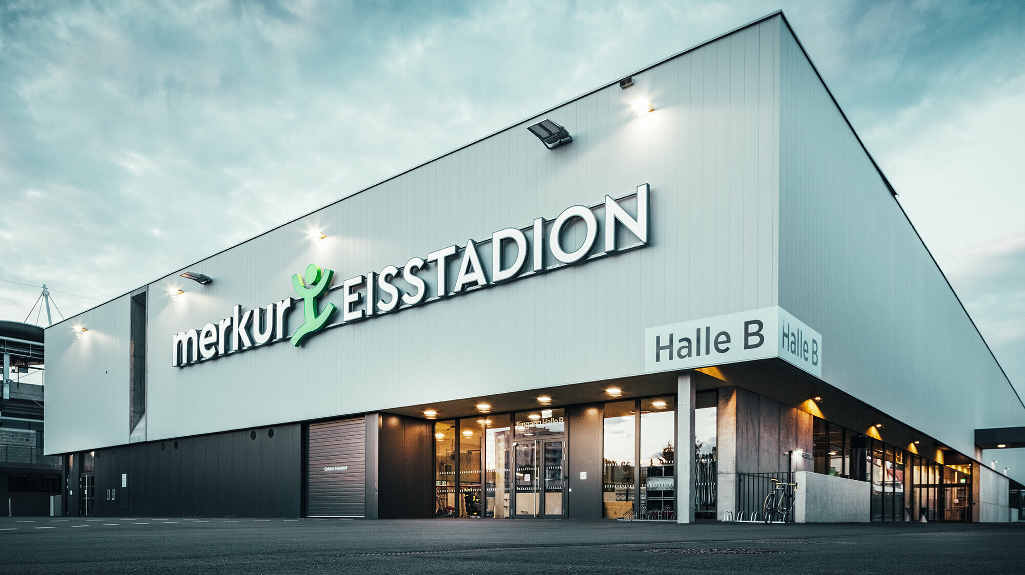 Frontansicht der Eishalle mit der Aufschrift "merkur EISSTADION"