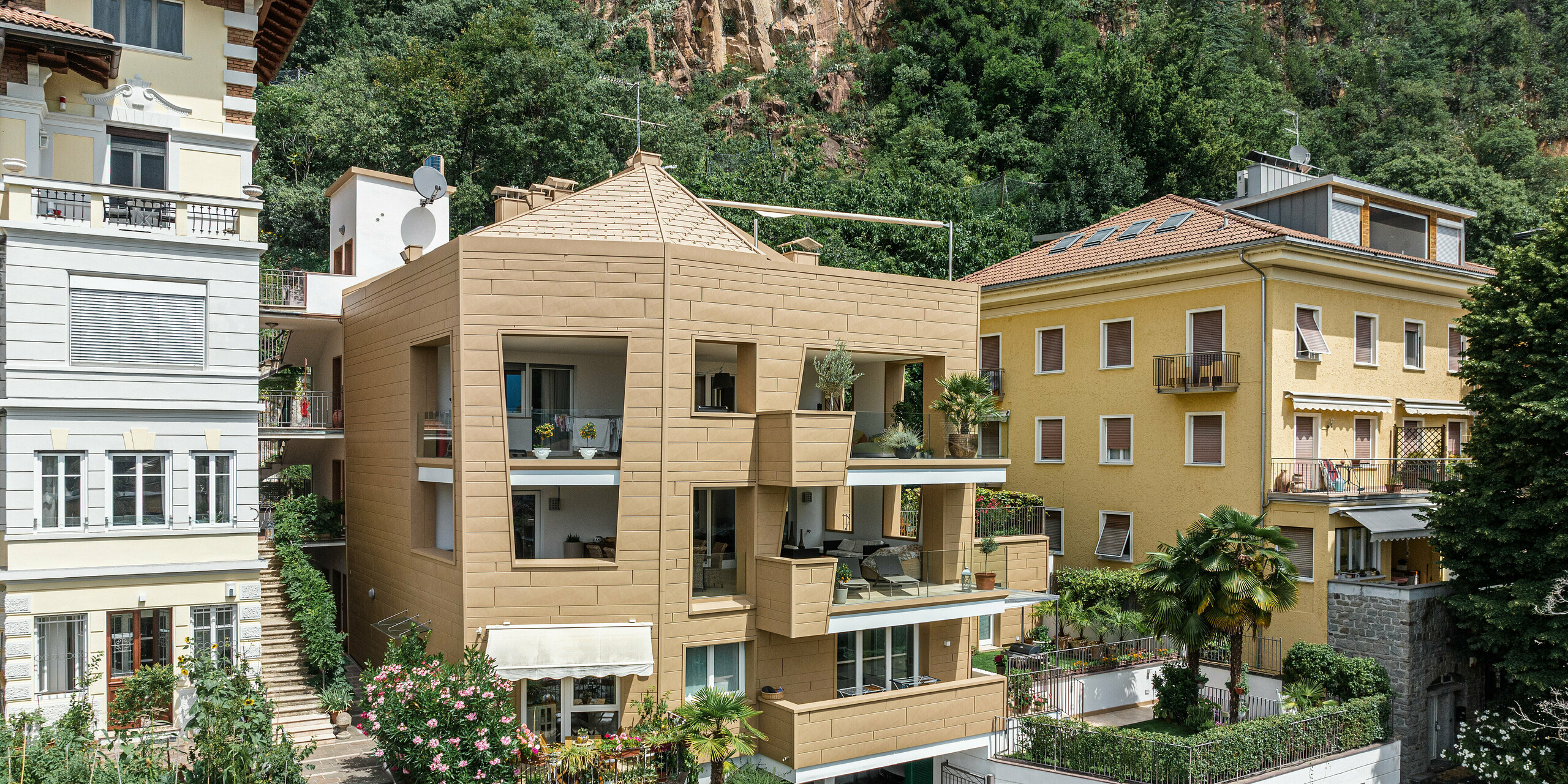 Die harmonische Integration von moderner Architektur in historische Umgebungen: Die 'Villa Laura' in Südtirol demonstriert diese Kunstfertigkeit mit einer Fassade und einem Dach aus PREFA Aluminium in P.10 Sandbraun. Die präzisen Linien der FX.12 Dachpaneele und Siding.X Fassadenelemente verleihen dem Bauwerk eine zeitgenössische Eleganz und dynamische Textur. Die Gebäudehülle reflektiert die traditionelle Bauweise der Region und stellt gleichzeitig eine innovative Nutzung von Material und Farbe dar, was die Villa zu einem Blickfang in der natürlichen Landschaft macht.