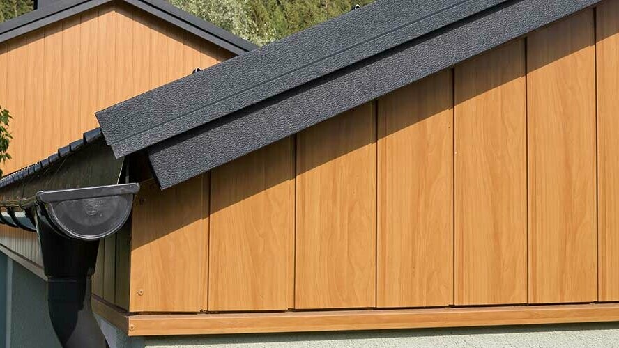 Topgevel bekleed met verticaal gemonteerde aluminium sidings van PREFA in eiken naturel, met PREFA dakgoot in antraciet.