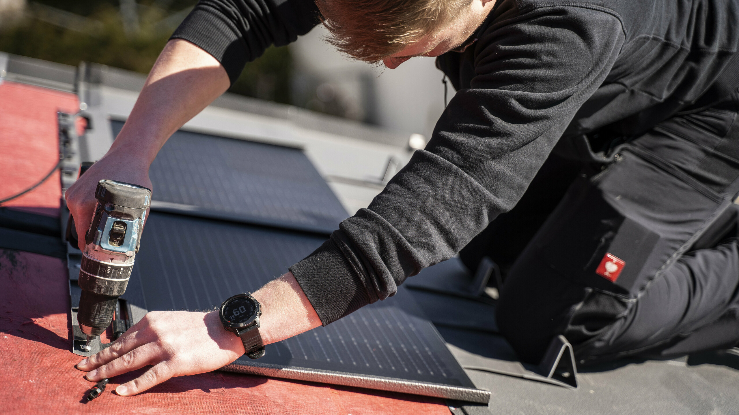 Een PREFA medewerker bij de plaatsing van de solar-dakpan.