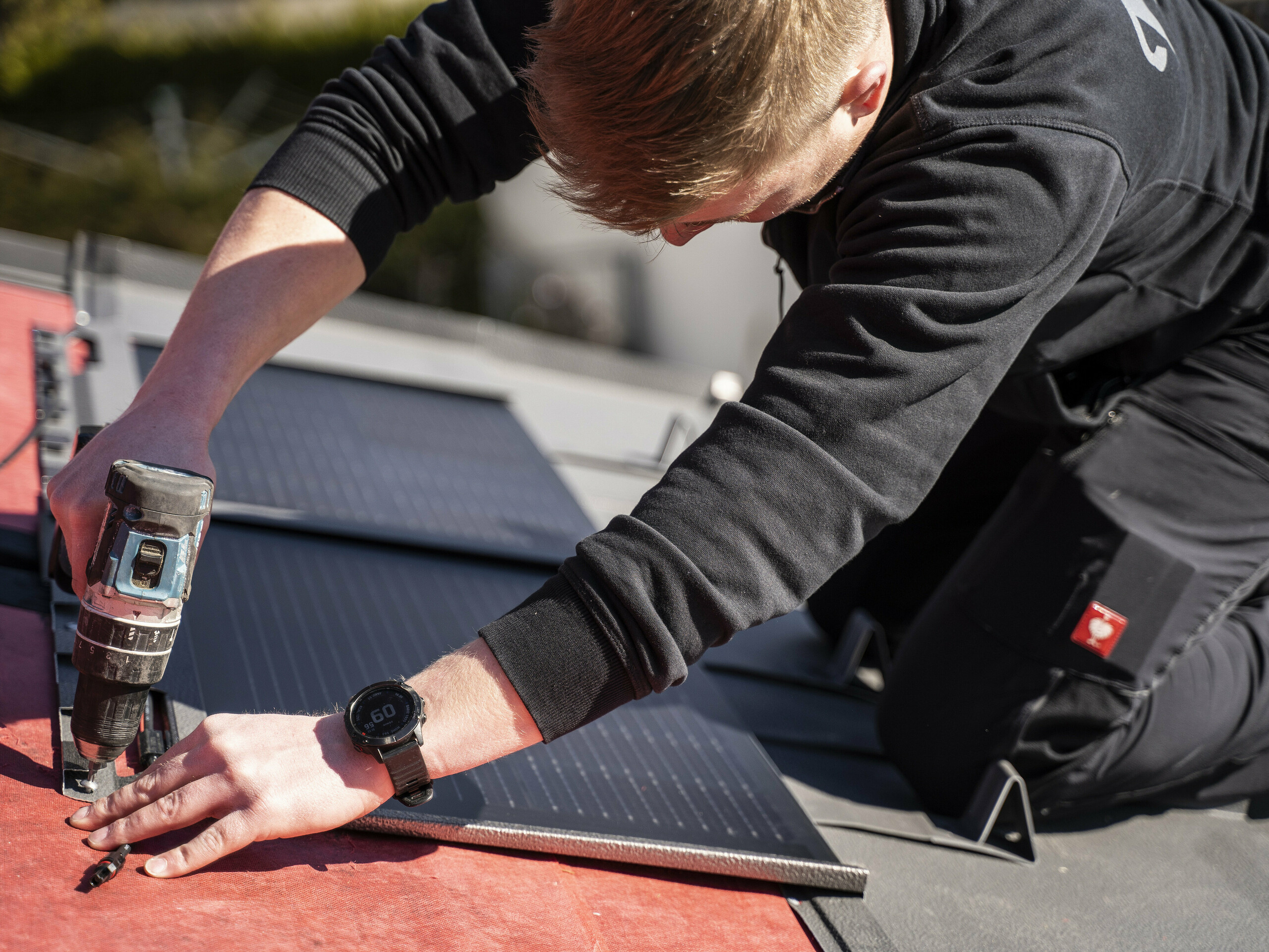 Een PREFA medewerker bij de plaatsing van de solar-dakpan.